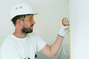 construction worker measuring a a wall | portland oregon porta potty rental for construction sites